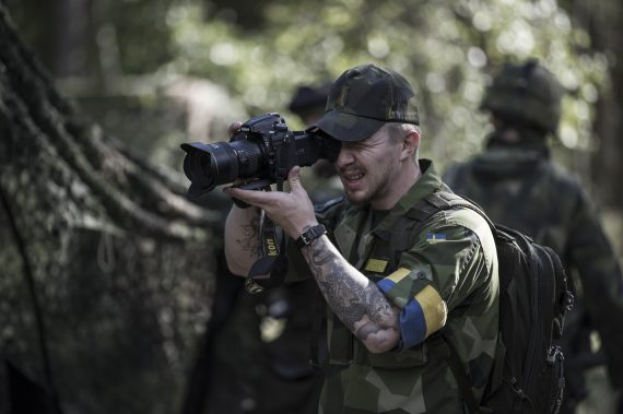 Här dokumenterar Croona ett par soldater som maskerar en lastbil. Maskering hör till kategorin fältarbete för överlevnad.