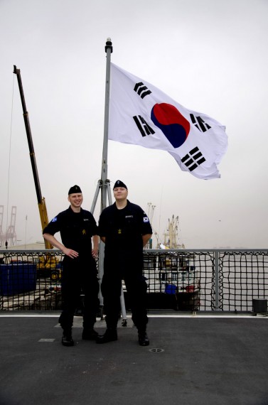 Sjömännen Marcus Rosenqvist och Martin Rundqwist vid den koreanska flaggan. Foto Försvarsmakten